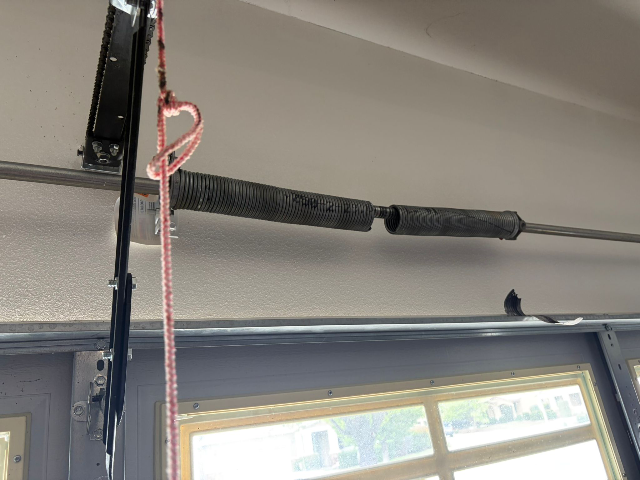 Broken spring on windowed garage door