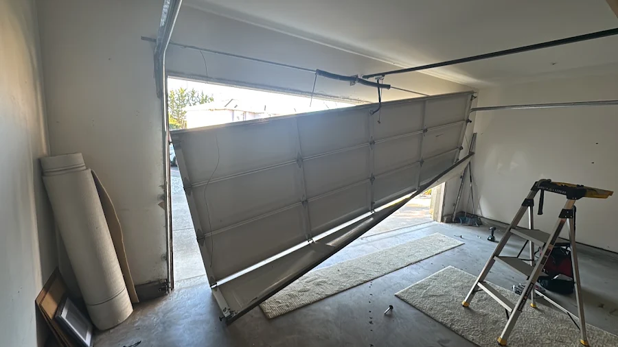 Garage door off track and hanging crooked before the repair, customer photo from a 5-star Google review of Noah Garage Doors in San Diego